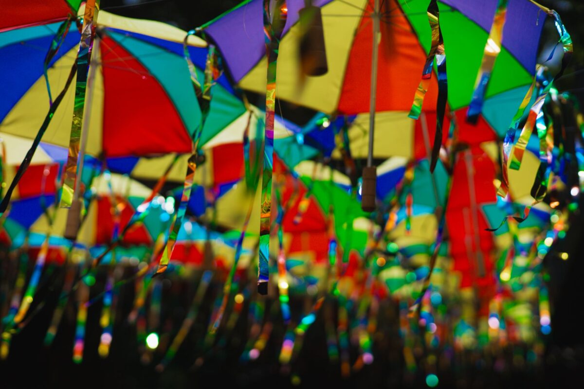 Arco de palha com balões e fitas coloridas